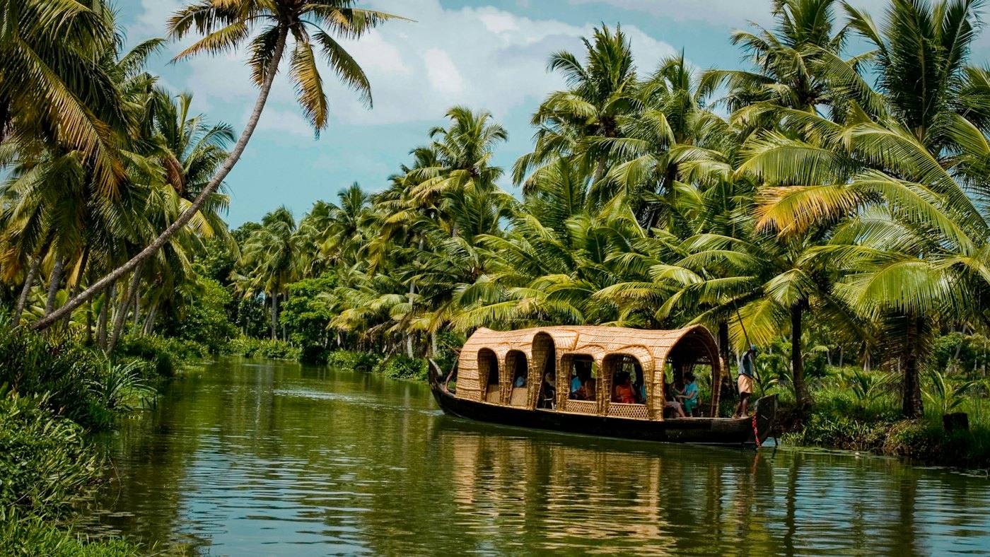 A traditional houseboat on a palm-lined backwater in Kerala