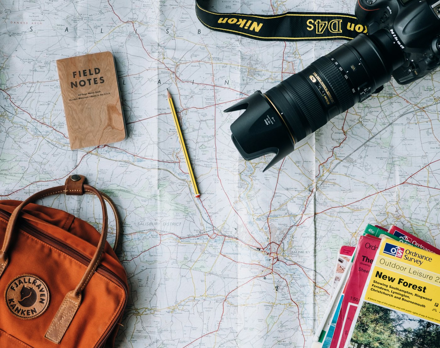 A map, notebook and camera laid out for trip planning